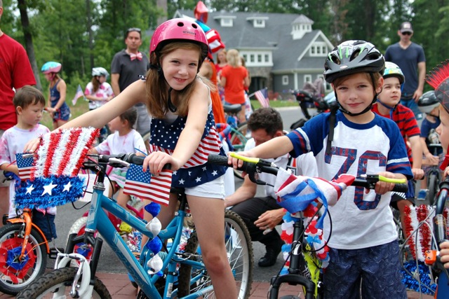 Children on bikes with american flags