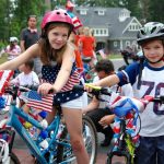 Children on bikes with american flags